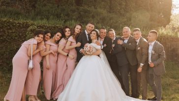 full-length portrait of the newlyweds and their friends at the wedding. The bride and groom with bridesmaids and friends of the groom are having fun and rejoicing at the wedding.