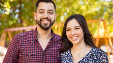 Attractive Latin young couple enjoying a sunny day outdoors and smiling