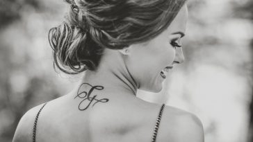 Portrait of young brunette girl with tattoo on the neck