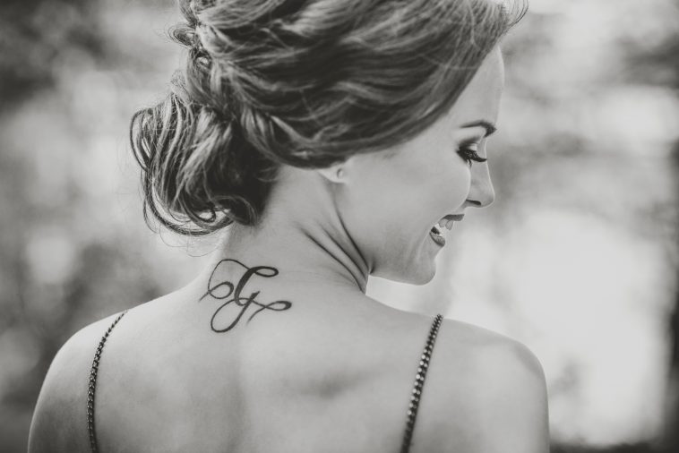 Portrait of young brunette girl with tattoo on the neck