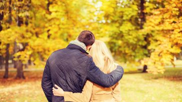 love, relationship, family and people concept - couple hugging in autumn park from back