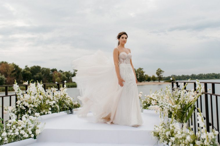 bride against the background of a yellow sunset on a pier near the river