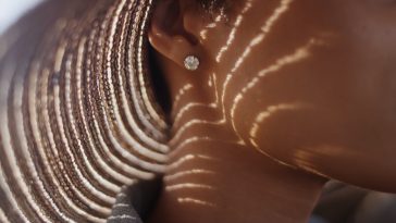 Extreme close up of Black woman with sunhat and diamond earing