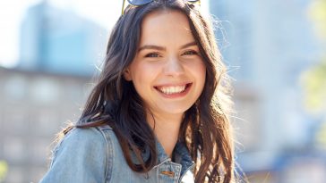 women and people concept - happy smiling young woman on summer city street