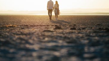 Couple in love walking on the beach and looking at each other