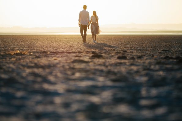 Couple in love walking on the beach and looking at each other