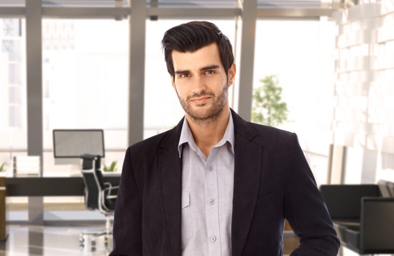 Portrait of goodlooking young businessman at office, smiling.