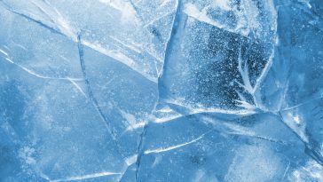 Abstract ice background. Blue background with cracks on the ice surface