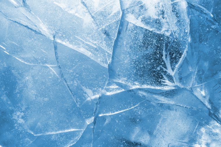 Abstract ice background. Blue background with cracks on the ice surface