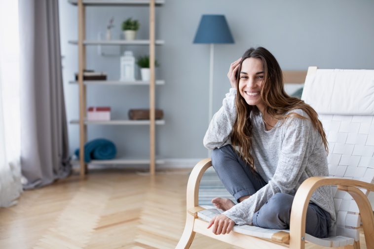 Home lifestyle woman relaxing on cozy chair in living room. Female portrait.