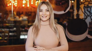 Portrait of a young pretty woman with pleasure posing at the camera in a cafe.