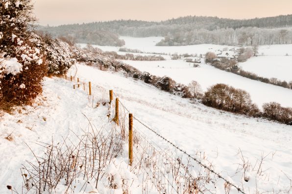 A view over some snow covered fields at dusk. Taken on Pewley Down in Guildford, Surrey on a snowy December evening.