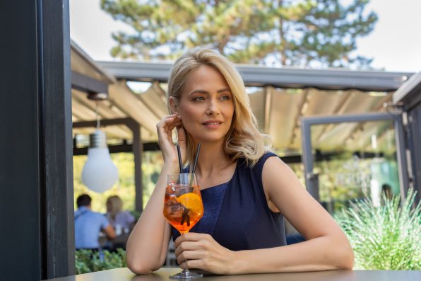 Beautiful business woman drinking cocktail in the restaurant alone