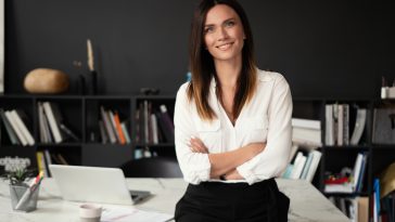 Confident stylish european middle aged woman standing at workplace. Stylish businesswoman, 30s lady executive leader manager looking at camera in office, portrait.