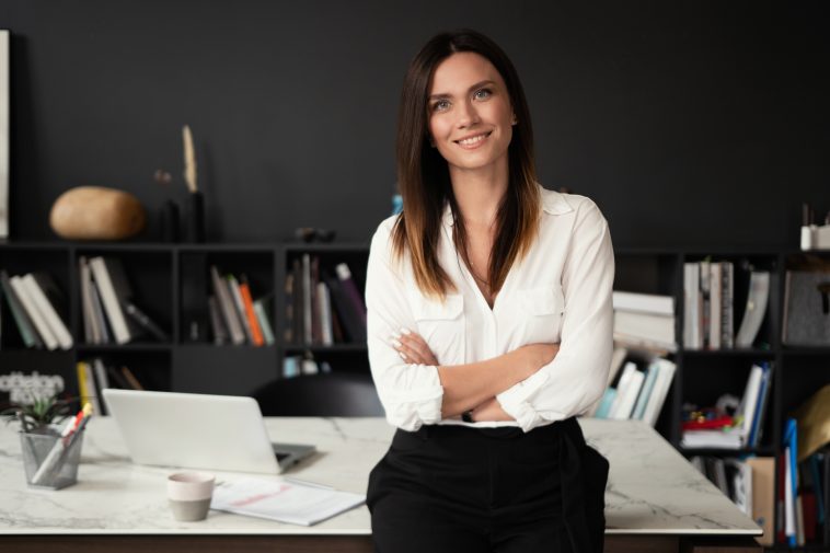 Confident stylish european middle aged woman standing at workplace. Stylish businesswoman, 30s lady executive leader manager looking at camera in office, portrait.