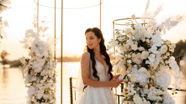 bride against the background of a yellow sunset on a pier near the river