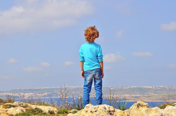 Lonely boy at the cliff edge. Between Malta and Gozo Islands