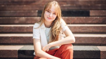 A young woman on street, generation z girl posing outdoor backlit with sunlight, portrait.