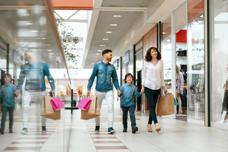 Family Shopping. Happy People With Child Carrying Bags, Walking In Modern Mall. High Resolution.