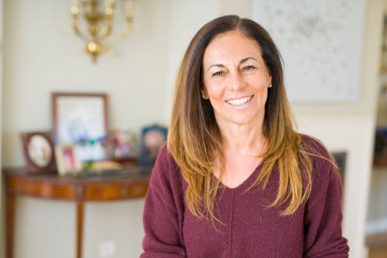 Beautiful middle age woman smiling at home