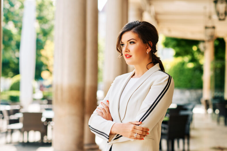 Outdoor portrait of beautiful stylish woman wearing white blazer