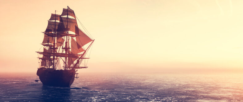 Pirate ship sailing on the ocean at sunset. Vintage cruise