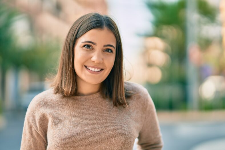 Young hispanic woman smiling happy standing at the city.