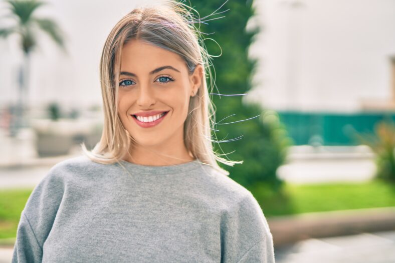 Young blonde girl smiling happy standing at the city.