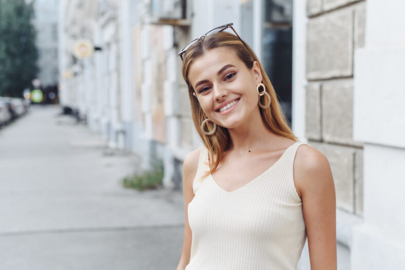 Happy young beautiful woman walking on the street. Image of beautiful stylish woman