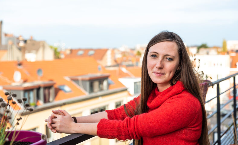 Portrait of an attractive thirty year old white woman in red posing on a , Brussels