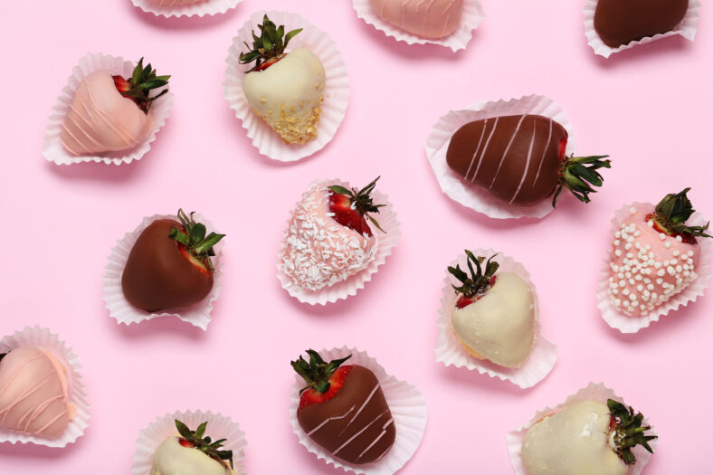 Strawberries covered in chocolate on a pink background