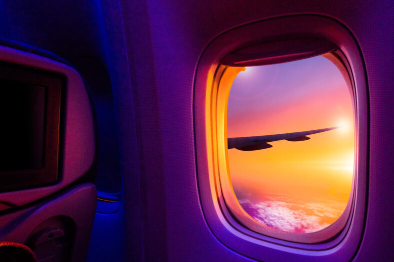 Beautiful scenic view of sunset through the aircraft window. Ima