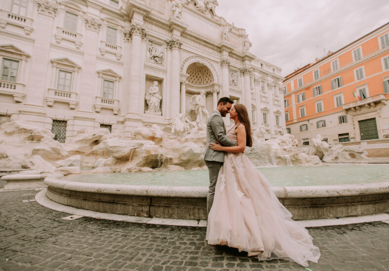 Just married bride and groom posing in front of Trevi Fountain (Fontana di Trevi), Rome, Italy