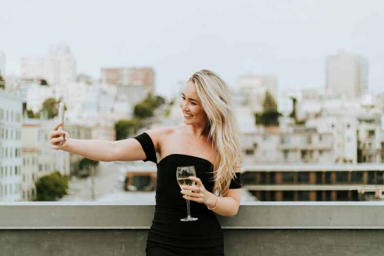 Cheerful woman taking a selfie at a rooftop party