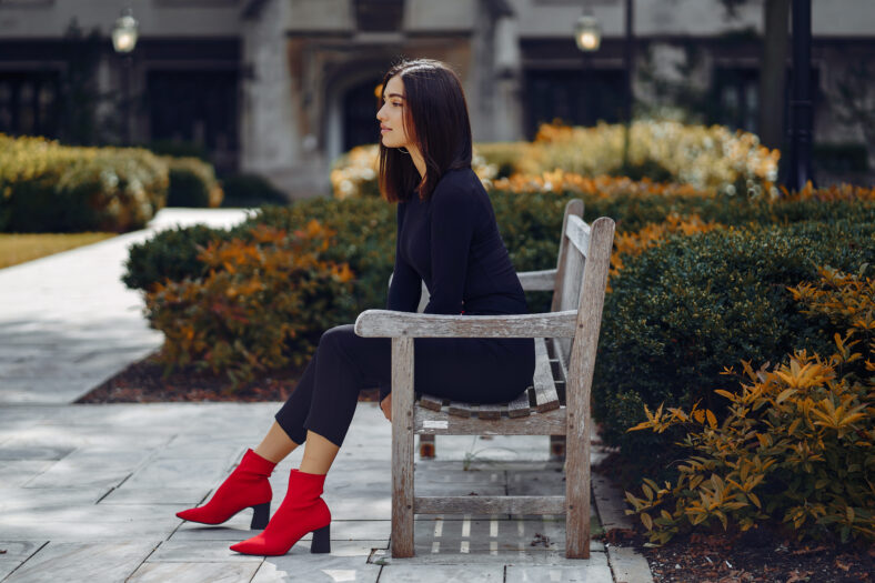 stylish girl sitting on a bench in Chicago waiting to meet friends