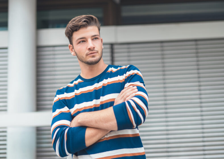 Guy posing with crossed arms. Portrait of handsome young man