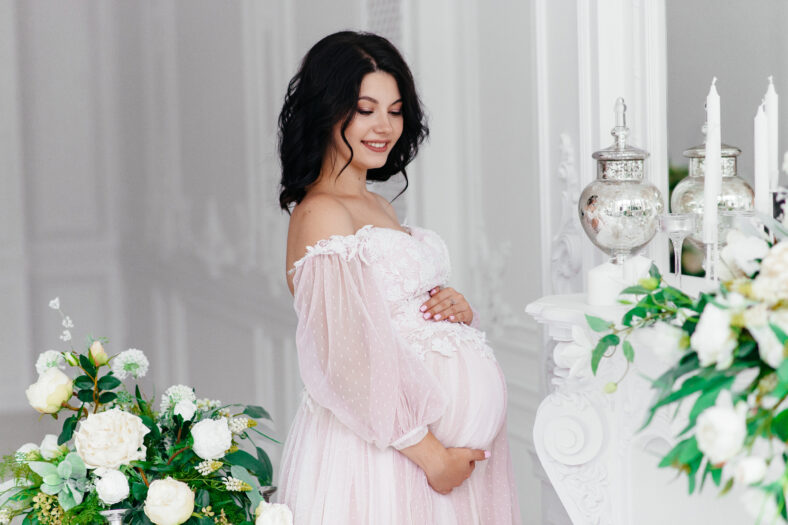 Beautiful pregnant girl in a dress in a bright room