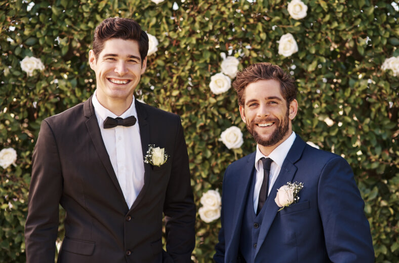 Groom, best man and wedding portrait outdoor with smile and happiness in nature. Happy men together in garden for formal celebration event with elegant clothes, suit and friends on green background.