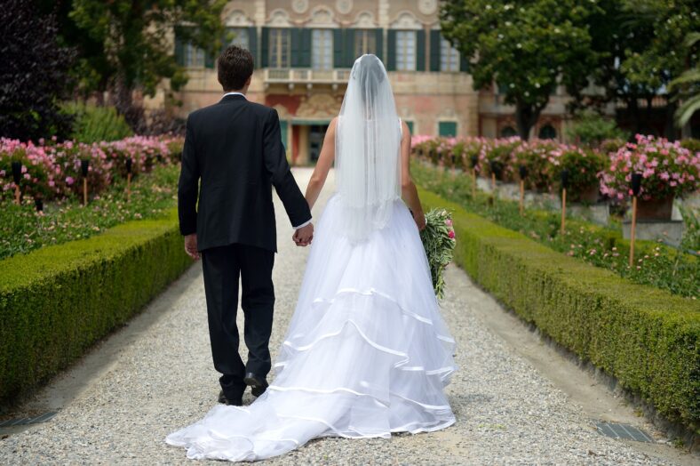 Bride and groom walking towards a villa.