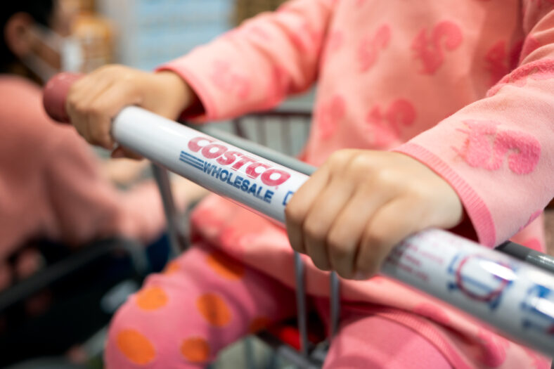 Un niño sentado en un carrito de compras de Costco