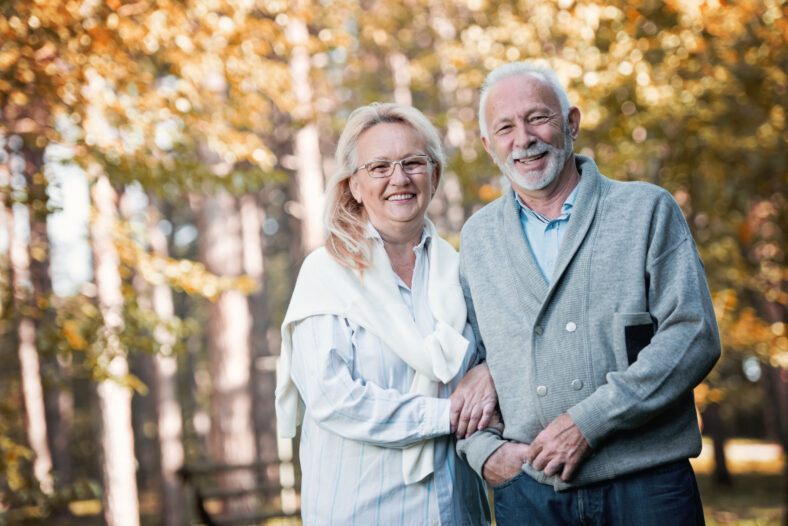 Feliz pareja de ancianos sonriendo al aire libre en la naturaleza