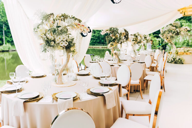 Wedding in a white tent by the lake. Beautiful flowers. luxurious wedding decor in white.